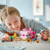 Girl is smiling as she plays with the built LEGO® Minecraft® The Axolotl House 21247 Building Toy Set (242 Pieces)