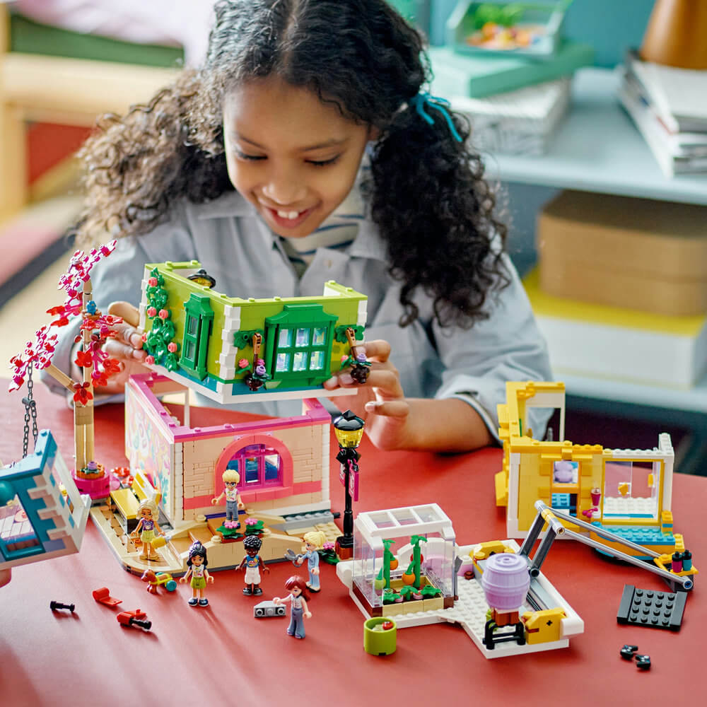 Girl building the LEGO® Friends Heartlake City Community Center 41748 Building Toy Set (1,513 Pieces)