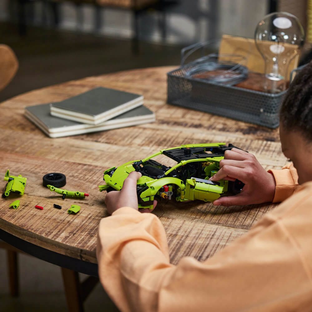 Person building the LEGO® Technic™ Lamborghini Huracán Tecnica 42161 Building Toy Set (806 Pieces)