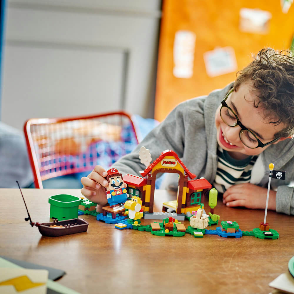 Child smiling and playing with the LEGO® Super Mario™ Picnic at Mario’s House Expansion Set 71422 (259 Pieces)