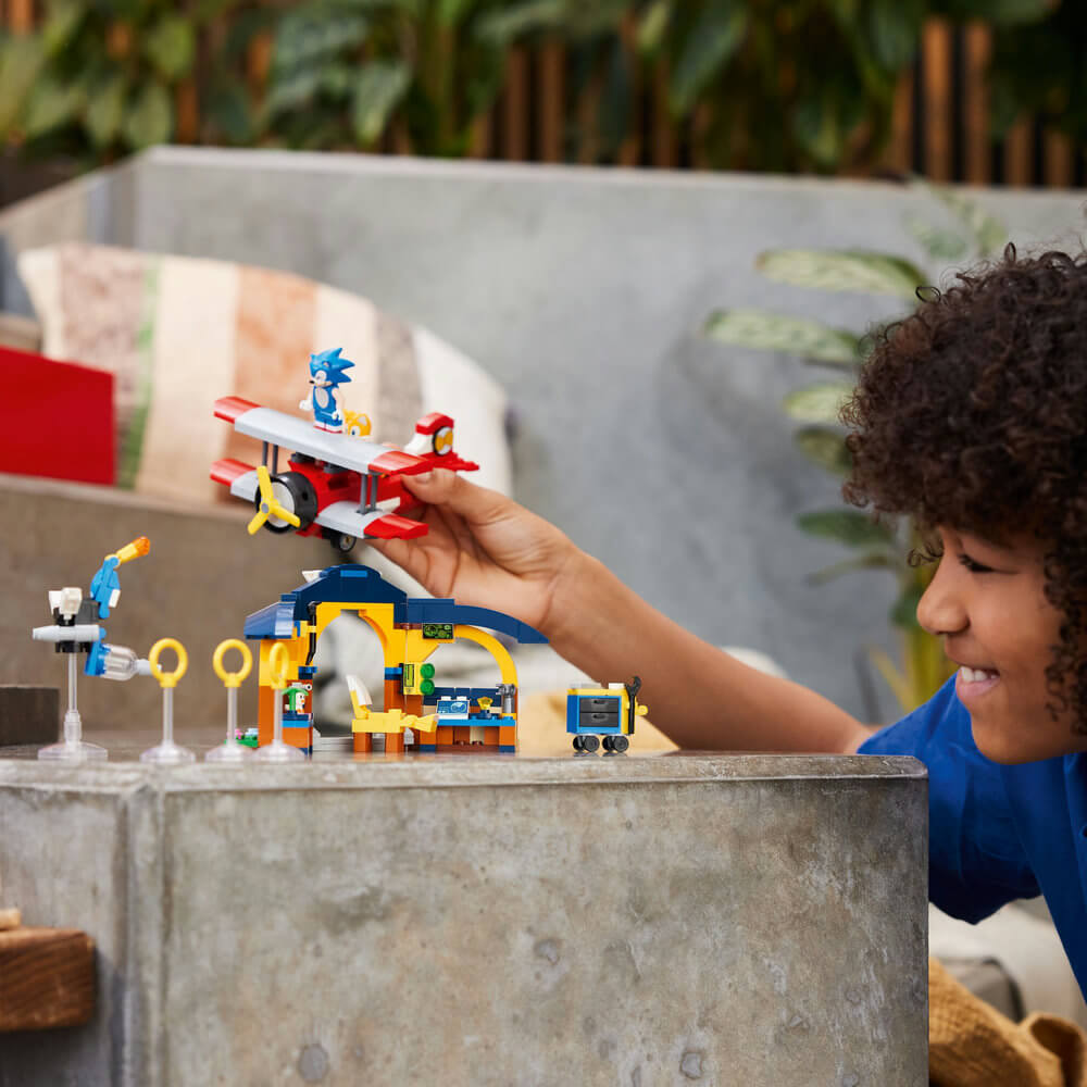 Child shown playing with the LEGO® Sonic the Hedgehog™ Tails’ Workshop and Tornado Plane 76991 (376 Pieces)