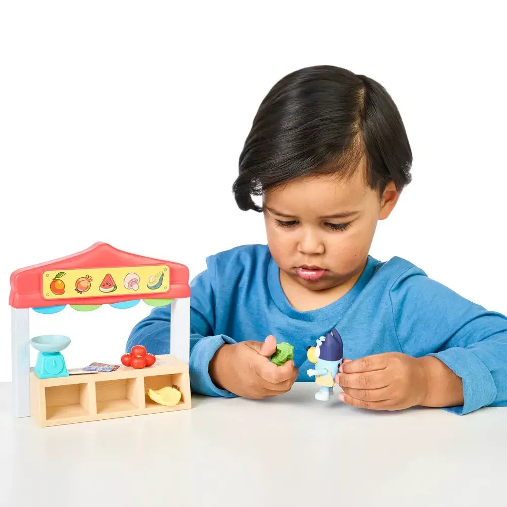 Boy playing with the Bluey Farmers Market Mini Playset and Bluey figure