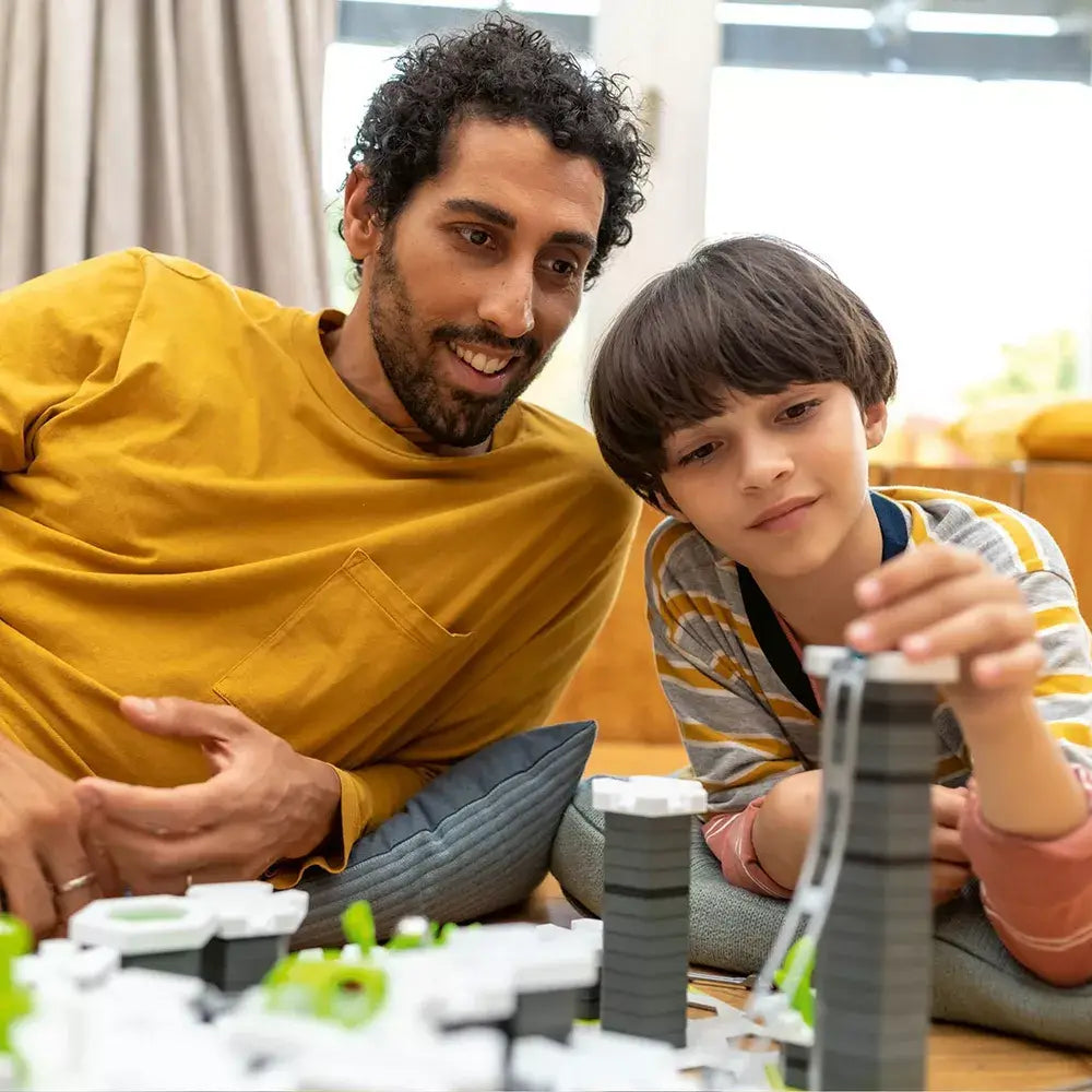 A father and son working together to put together GraviTrax pieces.