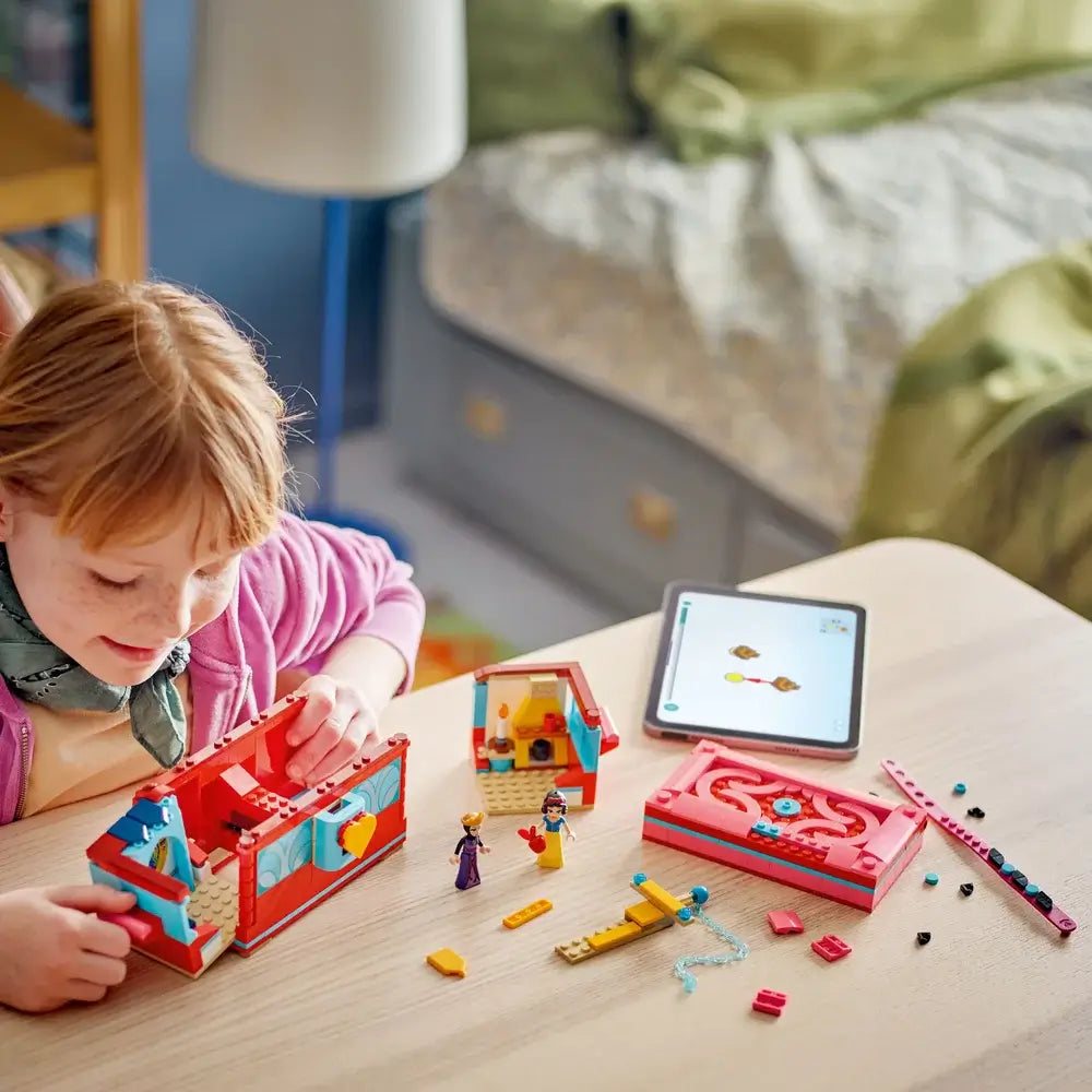 Image of girl wearing pink sweater playing LEGO® Disney Princess Snow White's Jewelry Box