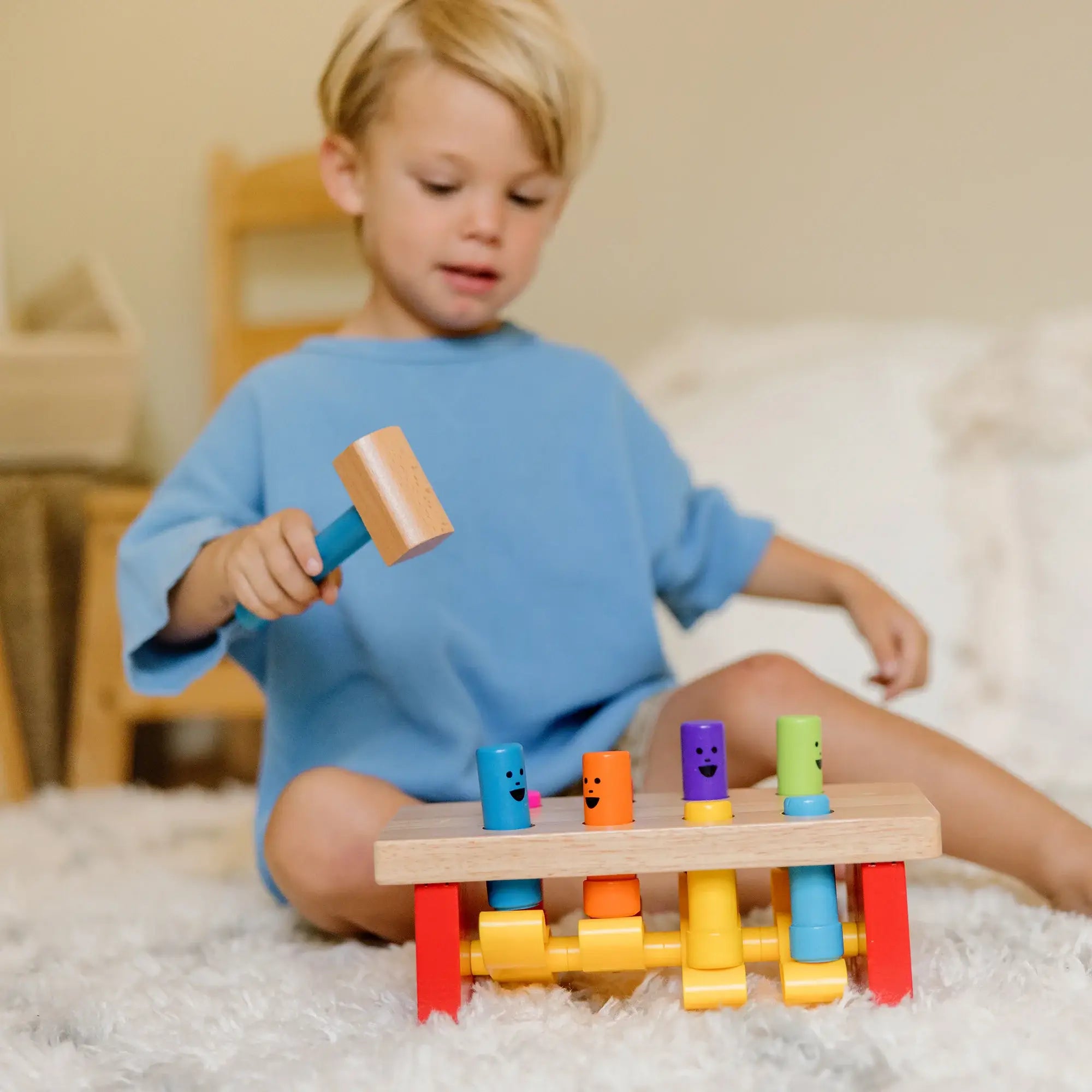 child pounding the Melissa and Doug Deluxe Pounding Bench with the hammer