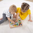 Boy wearing gray shirt and girl wearing yellow dress playing Farm Animal Puzzle 