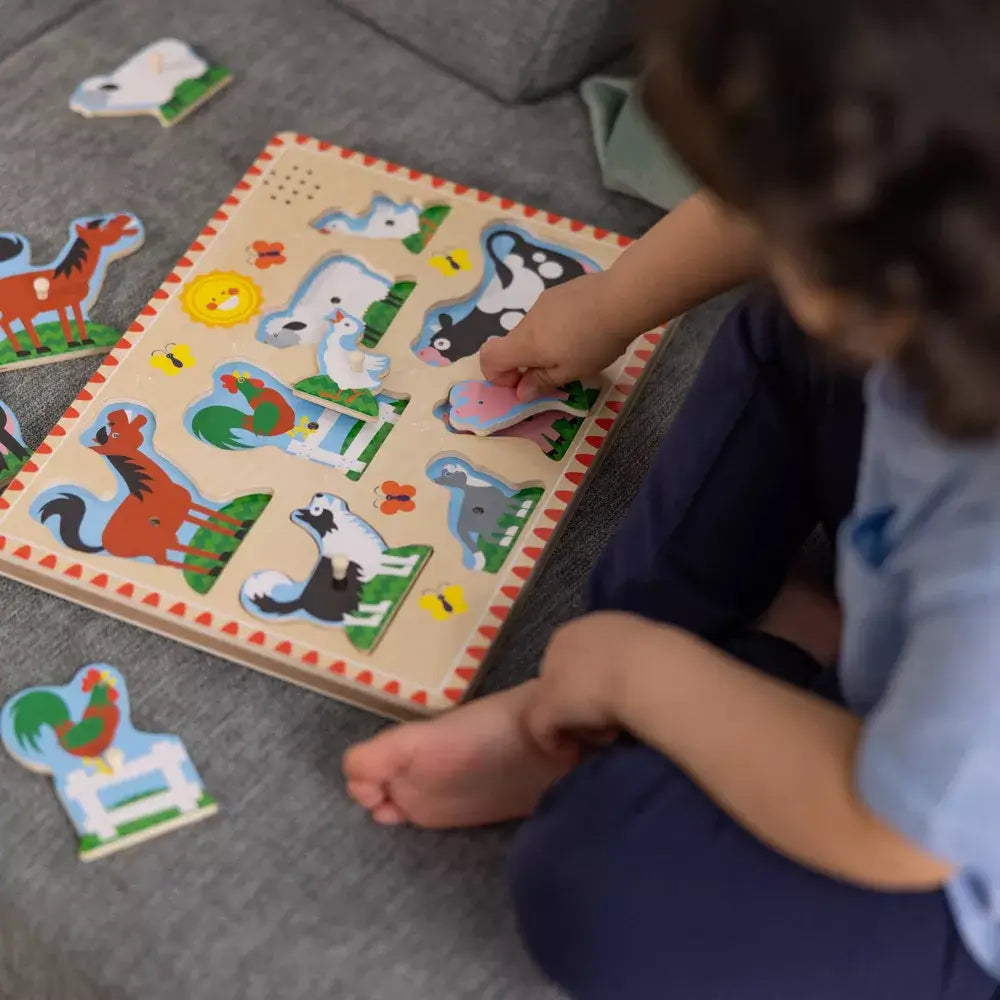 Girl wearing blue playing Melissa and Doug Farm Animals 8 Piece Sound Puzzle