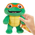 Teenage Mutant Ninja Turtles Mutant Mayhem Turtle Tot Michelangelo Plush being held in a hand.