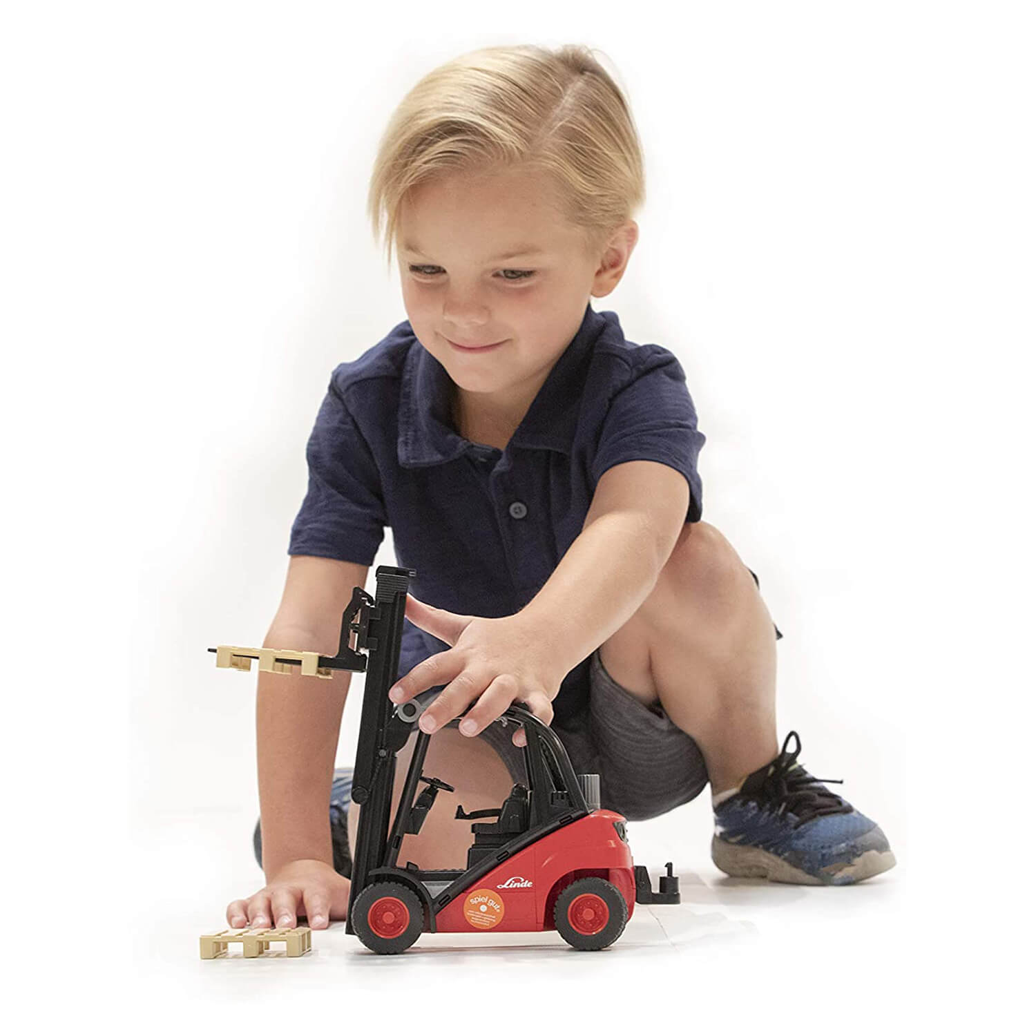 Kid playing with the fork lift vehicle.