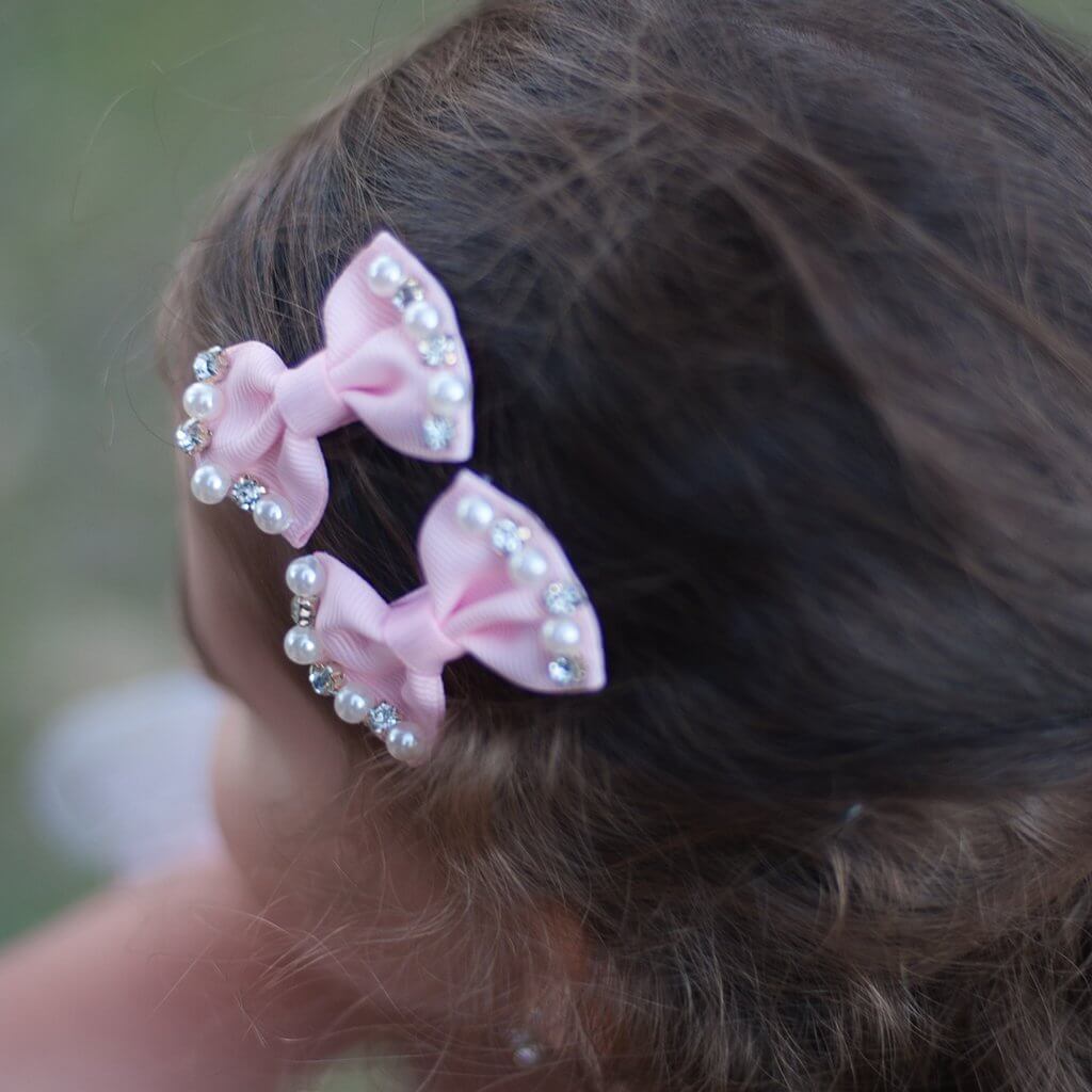 Front view of little girl wearing the Great Pretenders Princess & Pearls Hair Clips.