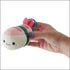 Person holding the Squishables Comfort Food Micro Shrimp Sushi plush keychain.