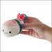 Person holding the Squishables Comfort Food Micro Shrimp Sushi plush keychain.